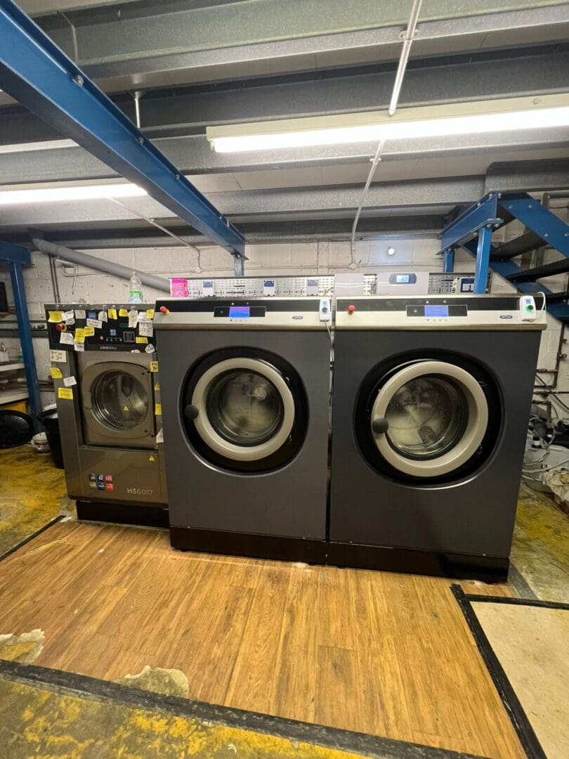 Industrial washing machines in a laundry facility.