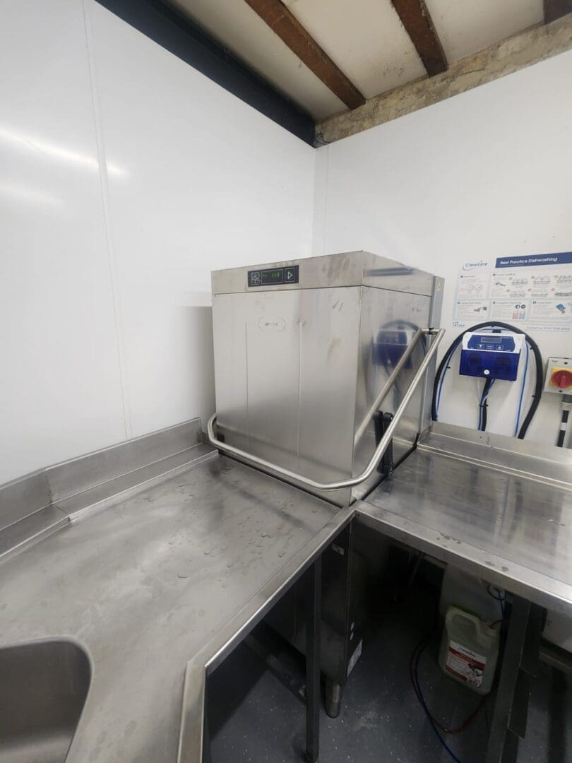 Commercial kitchen dishwasher with stainless steel counters.